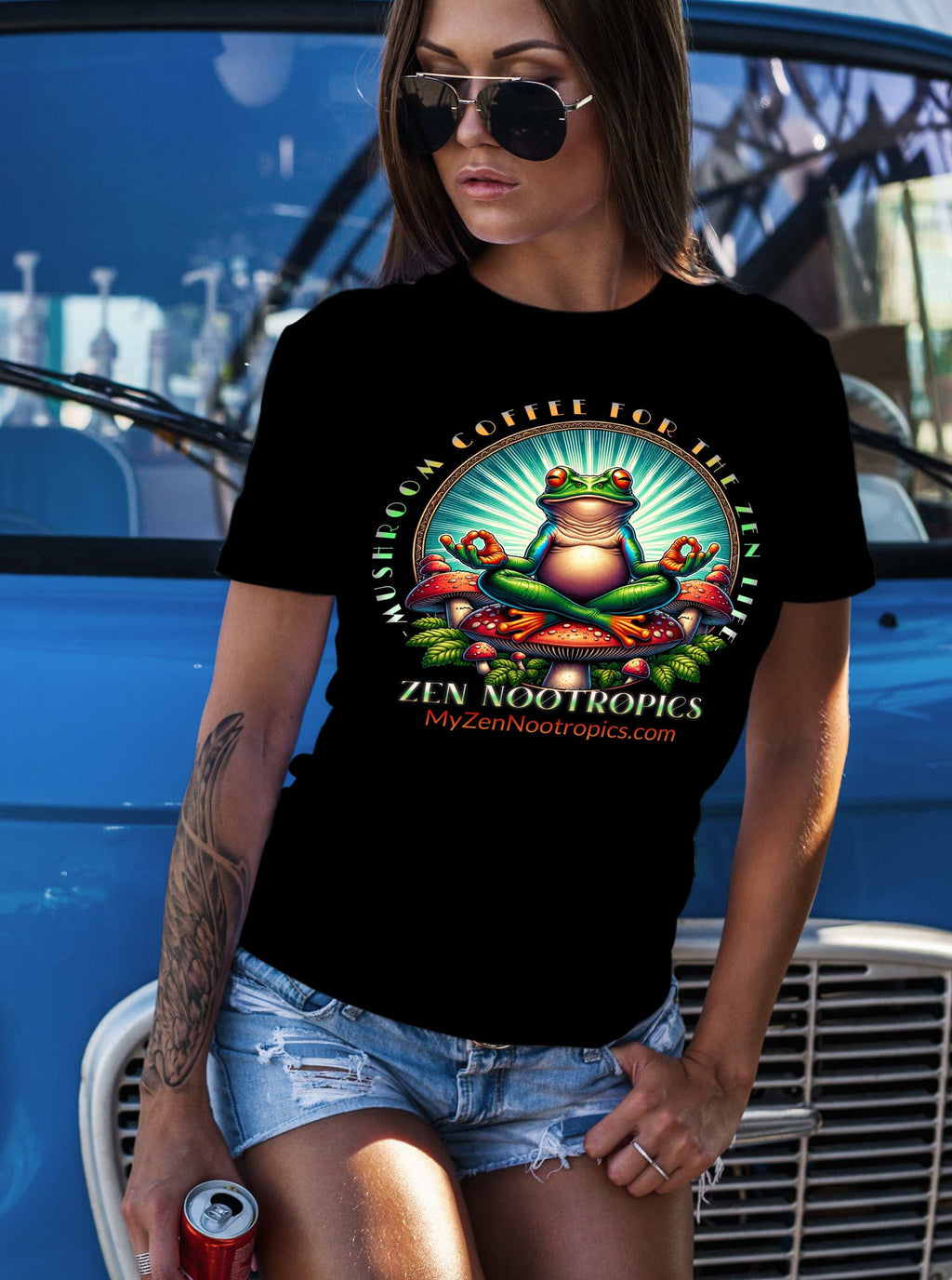Comfort Colors C1717 black t-shirt with colorful Zen Nootropics frog design, worn by woman with sunglasses and denim shorts outdoors